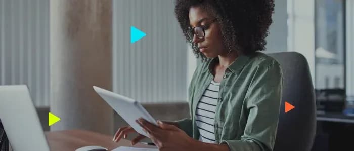 Mulher analisando dados em um tablet, ilustrando a consulta e monitoramento de clientes em bureau de crédito