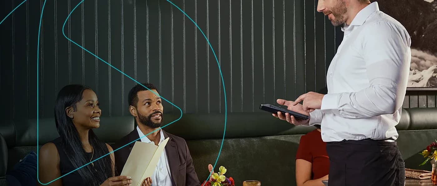 Garçom anotando o pedido de clientes em um restaurante com um tablet
