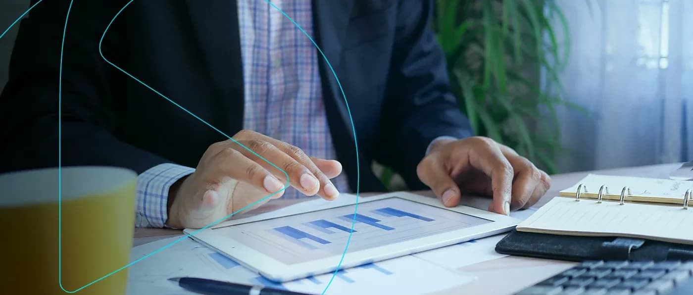 Gestor analisando gráficos de resultados em um tablet sobre a mesa de trabalho
