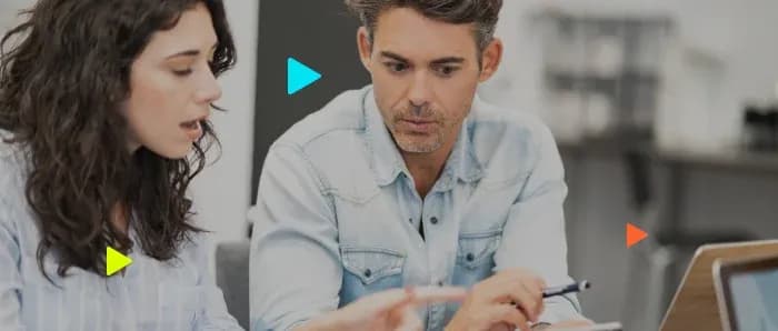 Dois profissionais analisando dados no notebook, ilustrando a consulta de restrição para evitar inadimplência.