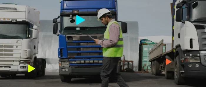 Homem com capacete inspecionando caminhões no pátio