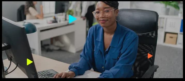 Mulher sorridente em escritório moderno usando computador