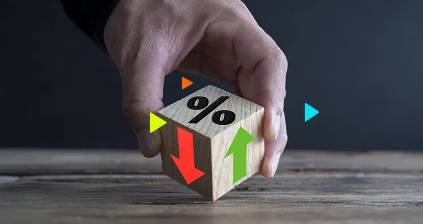 Empreendedor segurando um dado com lados ilustrados com seta vermelha, seta verde e porcentagem, representando o ativo e passivo.