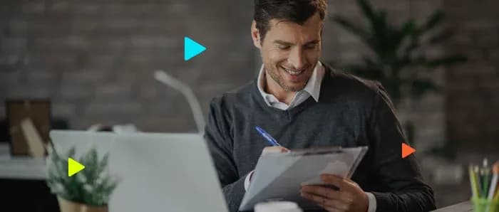 Homem sorridente escreve em clipboard no escritório