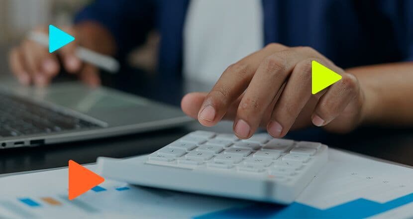 Pessoa usando calculadora e laptop para finanças.
