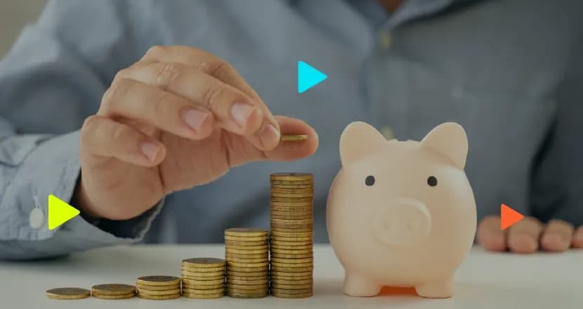 Mão empilhando moedas em ordem crescente ao lado de um cofrinho em formato de porco. Ícones coloridos de 'play' aparecem sobrepostos à imagem.