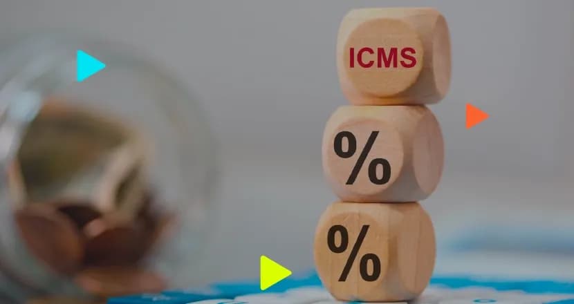 Três dados de madeira empilhados com a palavra "ICMS" e símbolos de "%", próximos a um pote com moedas desfocado. Ícones coloridos de 'play' sobrepostos.