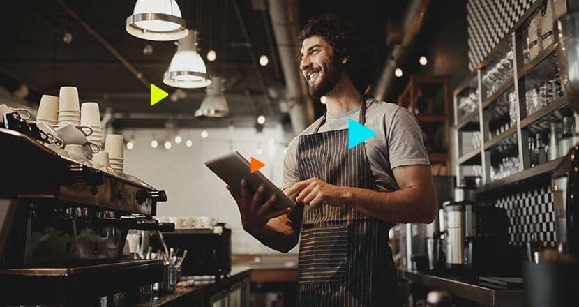 Barista sorridente usando tablet em cafeteria