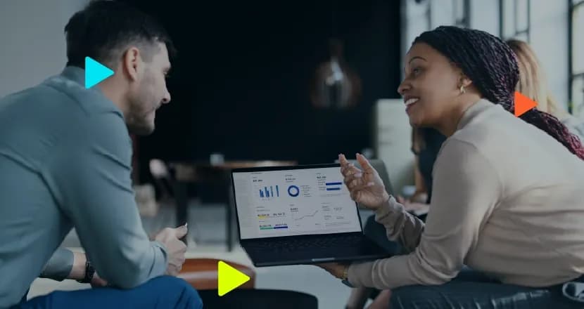 Profissionais debatem analisando dashboard de métricas em um notebook, ilustrando a medição conjunta de CAC e LTV.