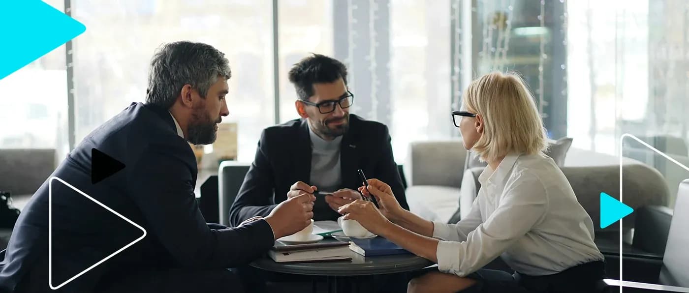 Três profissionais negociando em reunião numa mesa de café