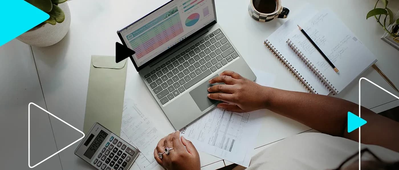 Pessoa usando notebook com planilha e calculadora sobre a mesa, cercada de notas e recibos