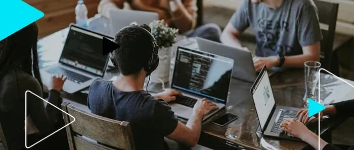 Equipe trabalhando em notebooks em uma mesa compartilhada