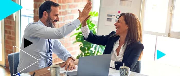 Empreendedores comemorando com um high five em reunião de trabalho
