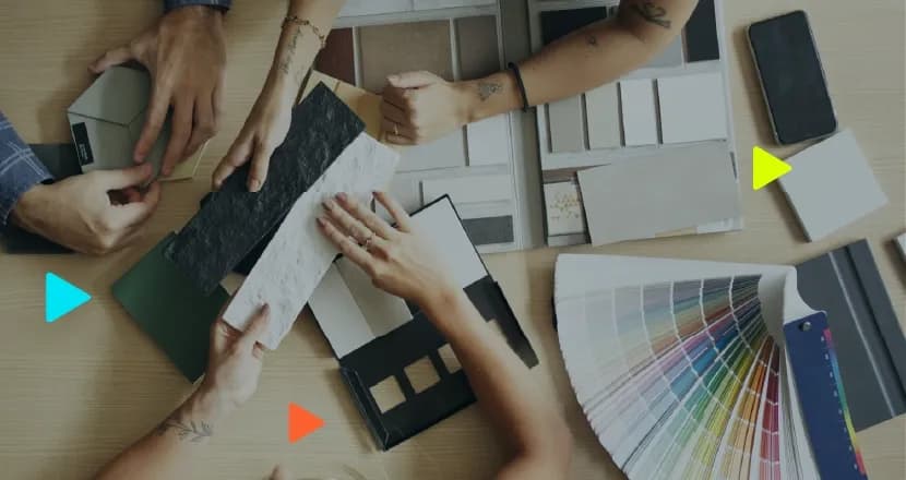 Equipe de arquitetura analisando amostras de revestimentos e paletas de cores sobre uma mesa.
