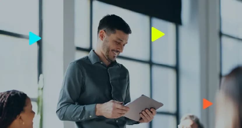 Representante comercial sorrindo com tablet durante reunião em escritório.