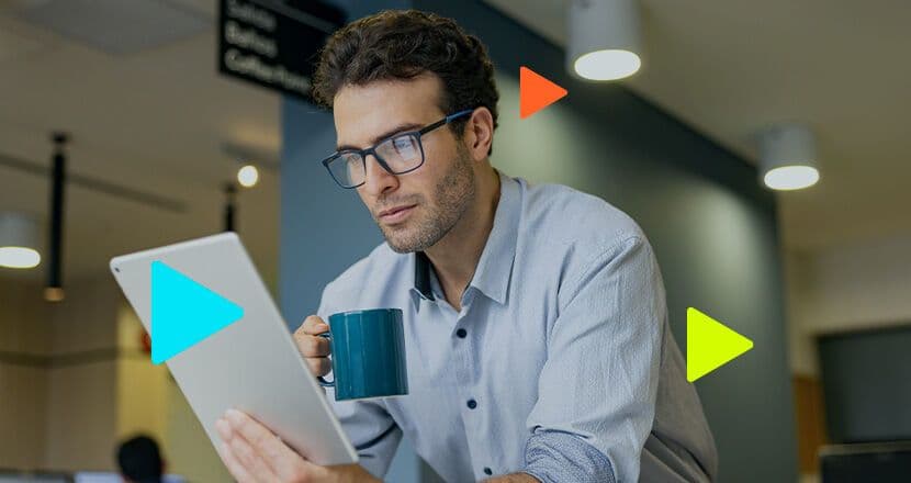 Homem analisando tablet com caneca na mão