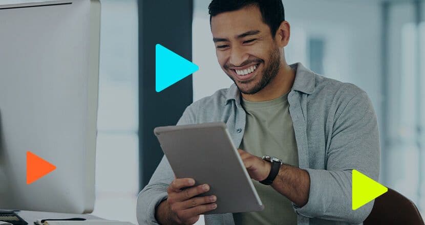 Homem sorridente usando tablet em ambiente de trabalho