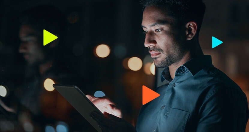 Homem olhando tablet com luzes ao fundo