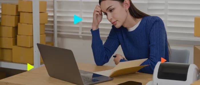 Mulher trabalhando em escritório com laptop e pastas.