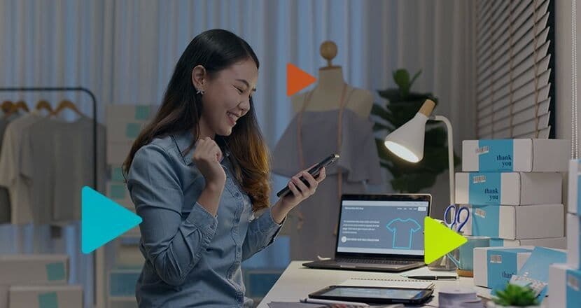 Mulher feliz usando o celular em um ambiente de trabalho.
