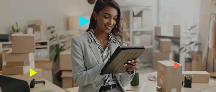 Mulher em ambiente de trabalho com tablet e caixas.