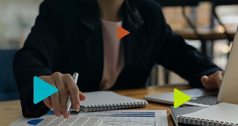 Pessoa analisando gráficos em mesa de trabalho