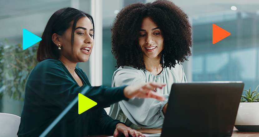 Duas mulheres discutindo em frente a um laptop.