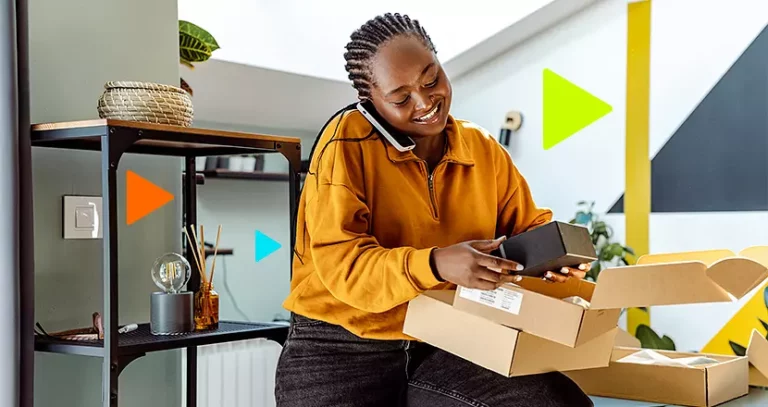 evitar chargeback: mulher com caixas na mão falando em celular