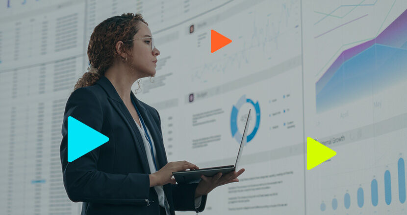 Mulher analisando gráficos em tela com laptop