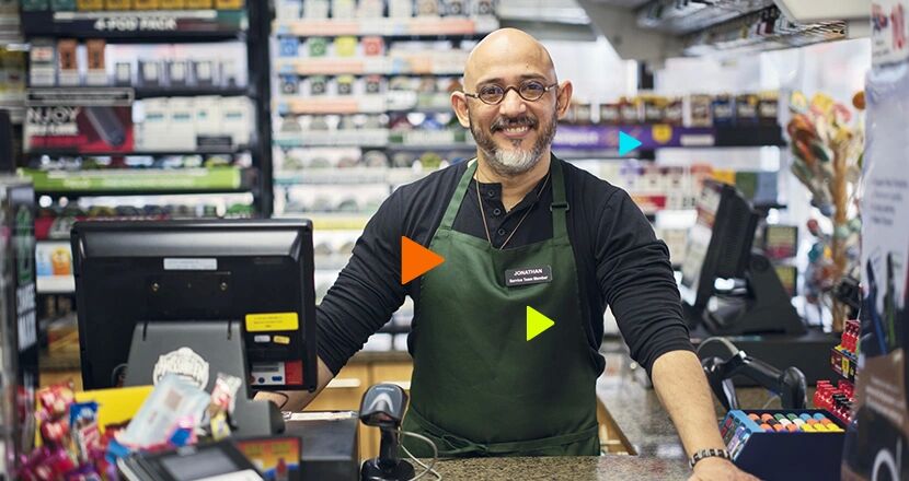 Funcionário sorridente em loja de conveniência