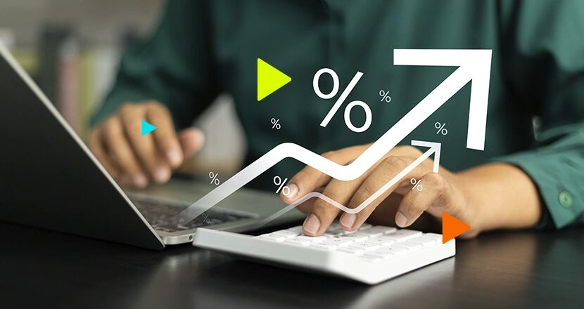 Homem digitando em laptop com gráficos de crescimento