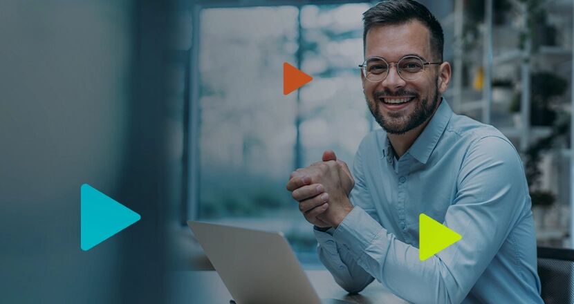 Homem sorridente em frente ao computador