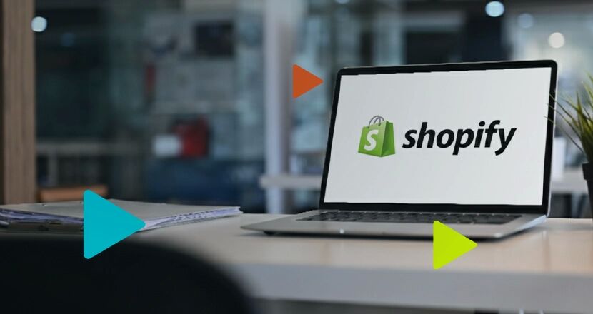 Laptop com logo da Shopify em ambiente de escritório