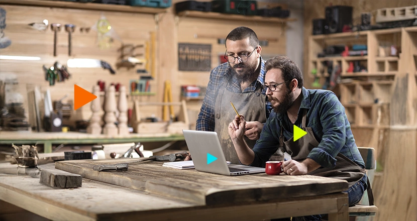 Dois rapazes sentados olhando para o notebook