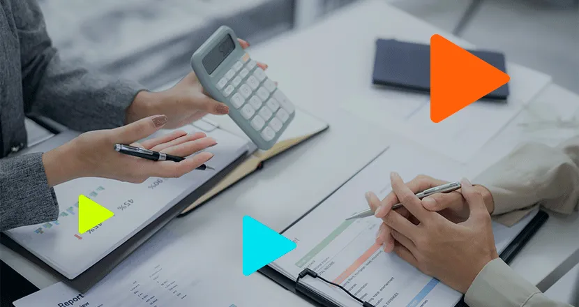 Profissionais discutindo resultados financeiros em mesa de escritório com gráficos.