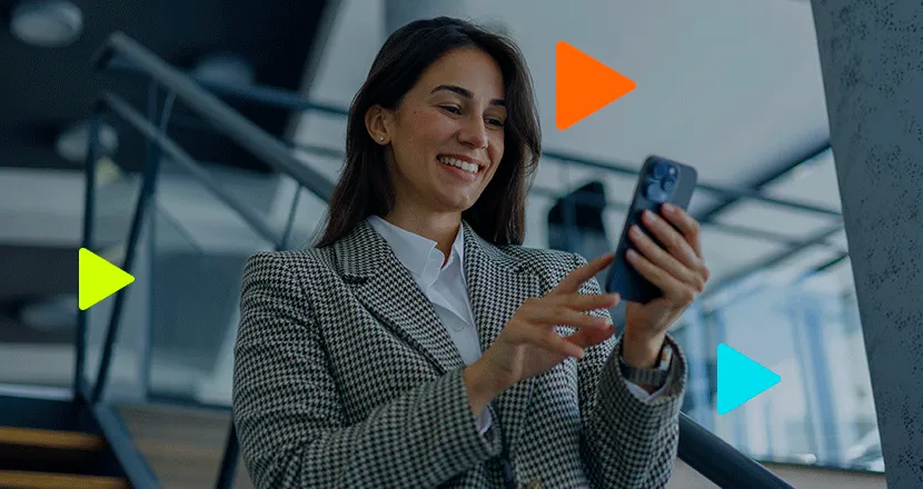 Mulher de negócios sorridente utilizando smartphone em ambiente de escritório.