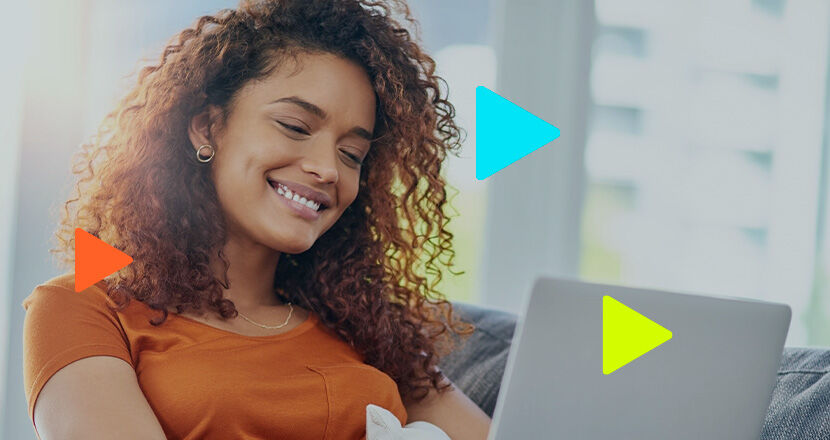 Mulher sorrindo enquanto usa laptop em ambiente aconchegante