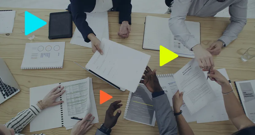 Reunião de equipe com documentos e gráficos sobre a mesa.