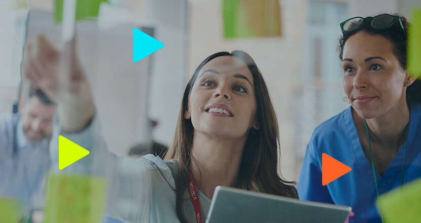 Duas mulheres colaborando em brainstorming com post-its.