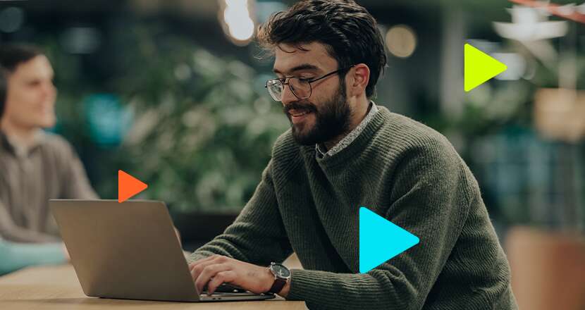 Homem jovem trabalhando em notebook em ambiente moderno.