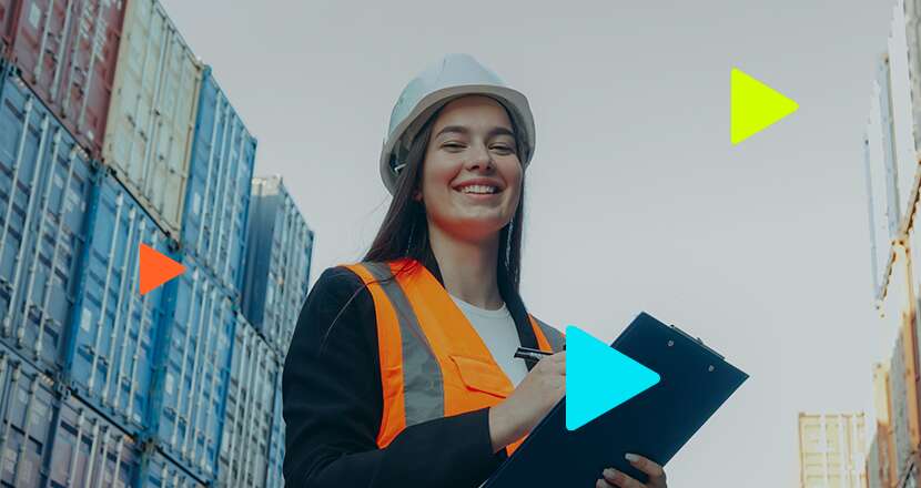 Mulher sorrindo com capacete em depósito de contêineres.