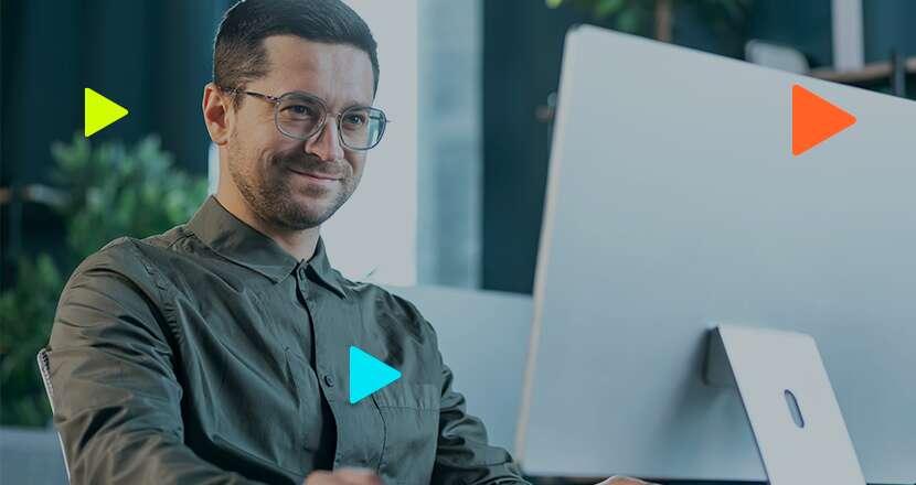 Homem sorridente em escritório moderno com computador
