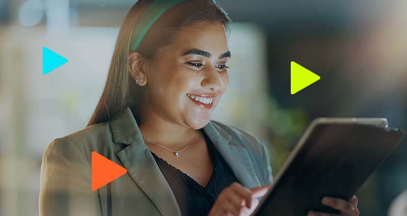 Blog da Omie 4 Mulher sorridente usando tablet em ambiente moderno