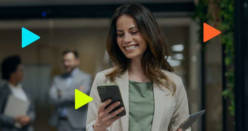 Mulher sorrindo com smartphone em ambiente de escritório