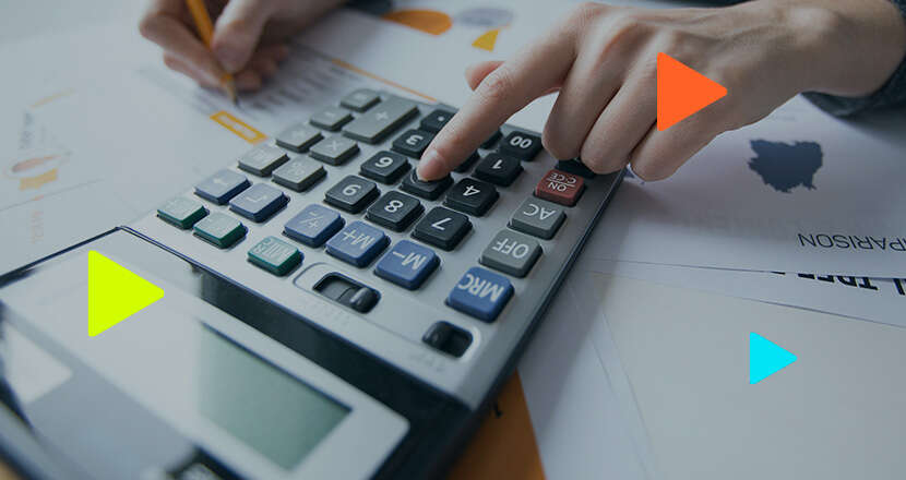 Blog da Omie 19 Pessoa usando calculadora em mesa de trabalho