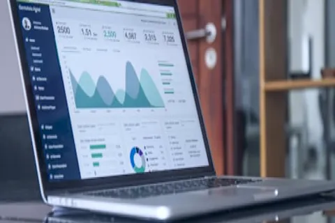 Pessoa analisando gráficos financeiros em notebook